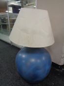 A painted glass carbouy converted to a table lamp