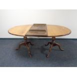 A Victorian oak oval twin pedestal dining table with leaf