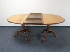A Victorian oak oval twin pedestal dining table with leaf