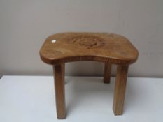 An oak four legged stool made by Peter R.