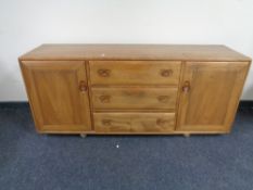 An Ercol solid elm double door sideboard with three central drawers, catalogue no.