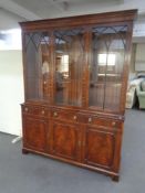 A mahogany triple door bookcase in Regency style and lion mask handles
