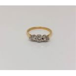 An 18ct gold three stone diamond ring, size N CONDITION REPORT: 2.