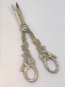 A very ornate pair of silver grape scissors depicting foxes.