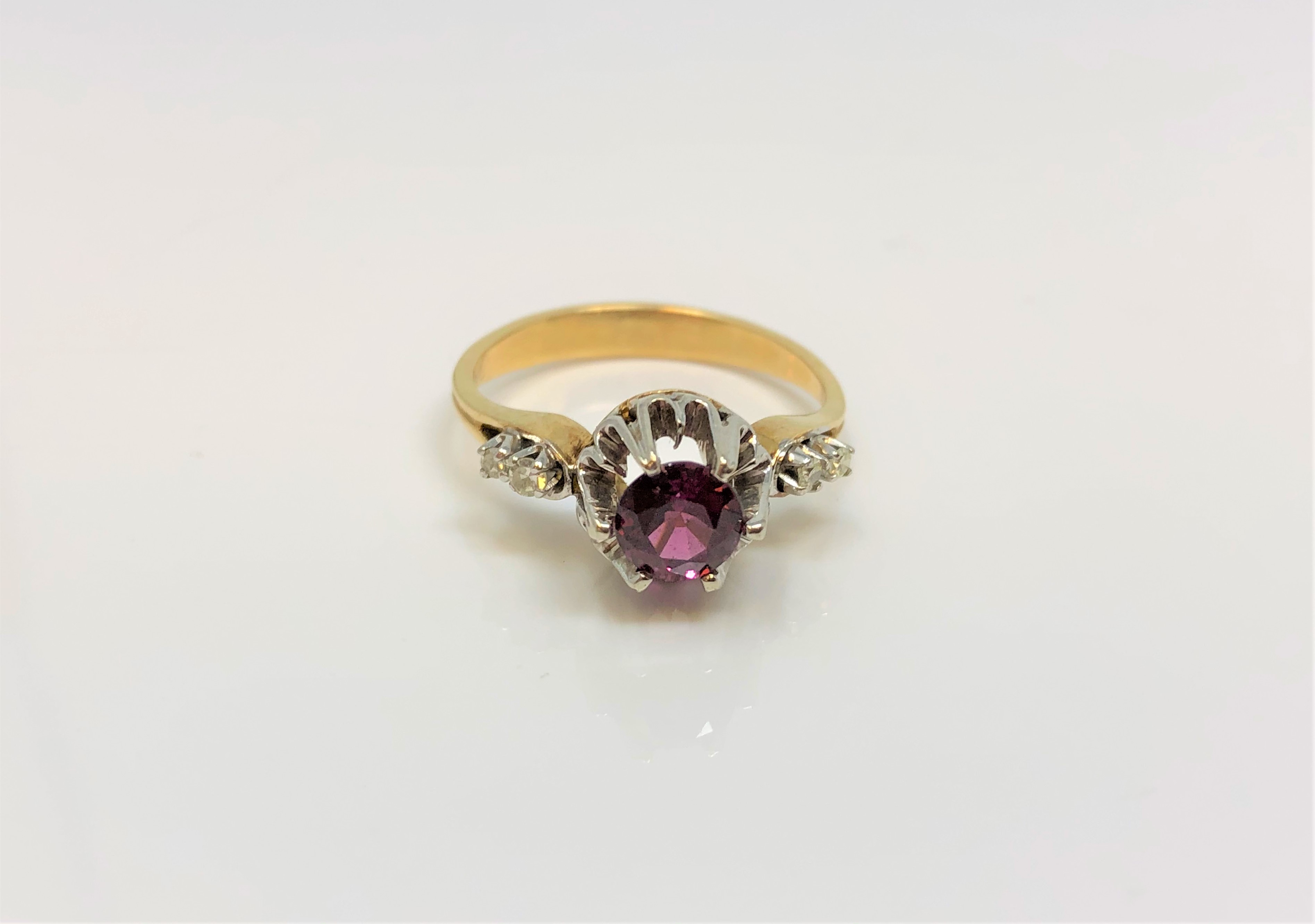 An 18ct yellow gold diamond set ring, the central stone possibly garnet, size O/P.