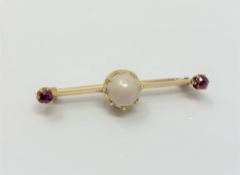 A yellow gold ruby and cultured pearl bar brooch CONDITION REPORT: Apparently