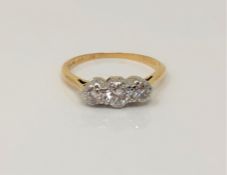 An 18ct gold and platinum three stone diamond ring, centre stone approx. 0.