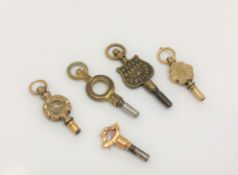 A gold pocket watch key and four others