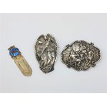 Two large ornate silver brooches and silver gilt clip.