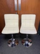 A pair of contemporary cream leather gas lift bar chairs