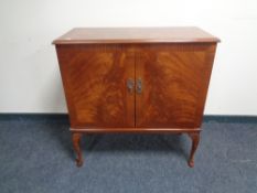 A reproduction mahogany double door television cabinet on raised legs