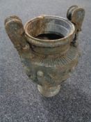 An antique metal twin handled urn embossed with figures dancing