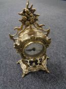 A decorative gilt metal quartz battery operated mantel clock with pendulum