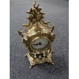 A decorative gilt metal quartz battery operated mantel clock with pendulum