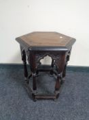 An Edwardian carved oak hexagonal occasional table