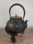 A Japanese cast iron teapot with gold inlay depicting stalks,