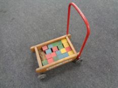 A vintage baby walker with wooden blocks