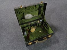 A green leather travel case containing three piece silver backed brush set and mirror,