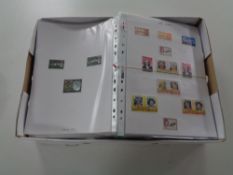 A box containing a large quantity of stamps of the world on paper in slip covers together with a