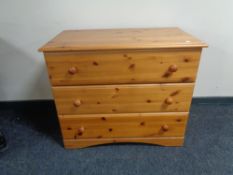 A contemporary pine effect three drawer chest