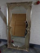 A shaped mirror in silvered swept frame