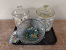 A tray containing assorted glass marbles together with two glass kitchen storage jars containing