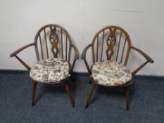 A pair of Ercol solid beech armchairs in an antique finish