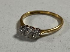 An 18ct gold three stone diamond ring in box