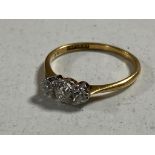 An 18ct gold three stone diamond ring in box