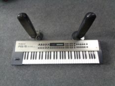 A Roland RX-5 64 voice synthesizer together with a pair of Samsung surround sound speakers