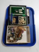 A tray containing costume jewellery to include simulated and beaded necklaces, gilt locket on chain,