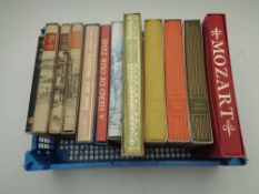 A basket containing 12 Folio Society volumes to include Tennyson, A Hero of Our Time, Mozart etc,