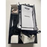 A box containing Chanel gift bags and Pandora earring boxes
