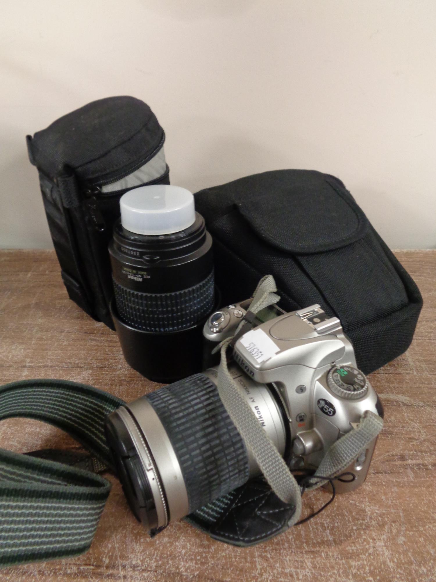 A Nikon F55 camera in case together with Nikon lens in fitted bag and other camera accessories