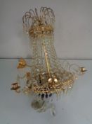 An early twentieth century brass five-way light fitting with blue glass shade and drops