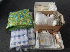 Three boxes containing table linens, cushions, floral quilt,