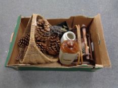 A box containing wicker basket containing pine cones, stone wear hot water bottle, metal trivets,