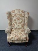A wingback armchair upholstered in a floral fabric
