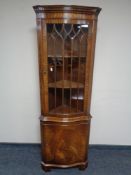A mahogany Regency style serpentine fronted corner display cabinet.