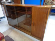 A set of mid 20th century sliding glass door bookshelves fitted a cupboard