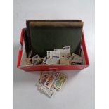 A shoebox containing Brooke Bond tea cards, an album of stamps and further collectors cards.