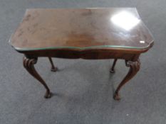 A mahogany turnover top games table on cabriole legs.
