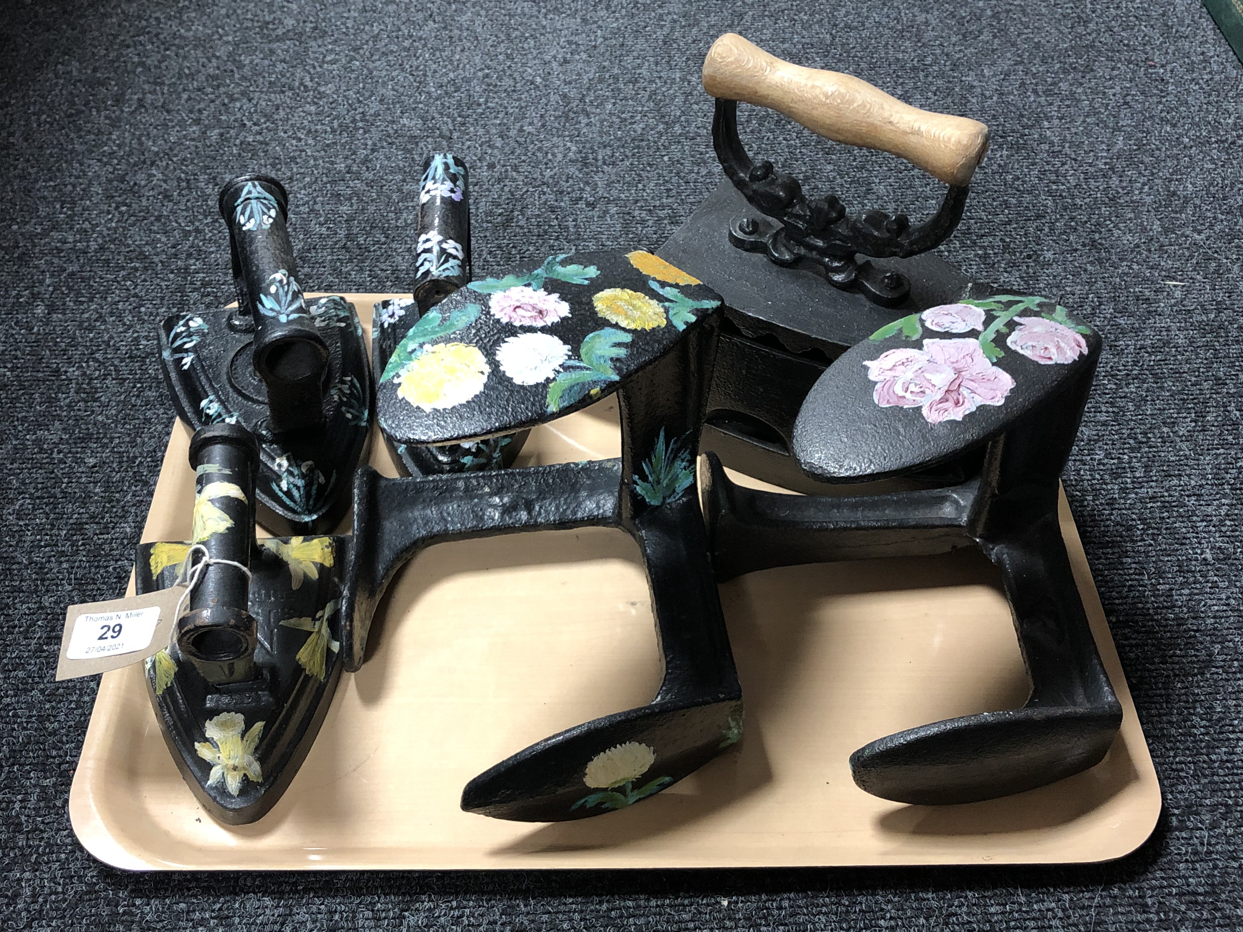 A tray of antique cast iron boot lasts and flat irons.