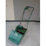 A Qualcast Suffolk electric lawn mower with box and extension lead