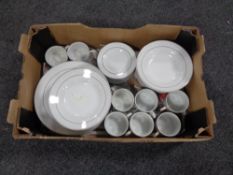 A box containing 40 pieces of white silver rimmed dinner ware.