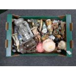 A box containing Continental figurines, oil lamps, Ringtons teddy bear, money box etc.