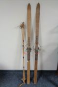 A set of vintage wooden skis together with a set of bamboo ski poles.