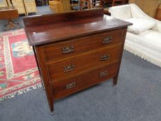 An Edwardian inlaid three drawer chest with copper drop handles.