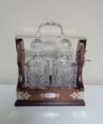 A Tantalus containing two cut glass whisky decanters