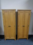 A pair of contemporary narrow oak double door cabinets.